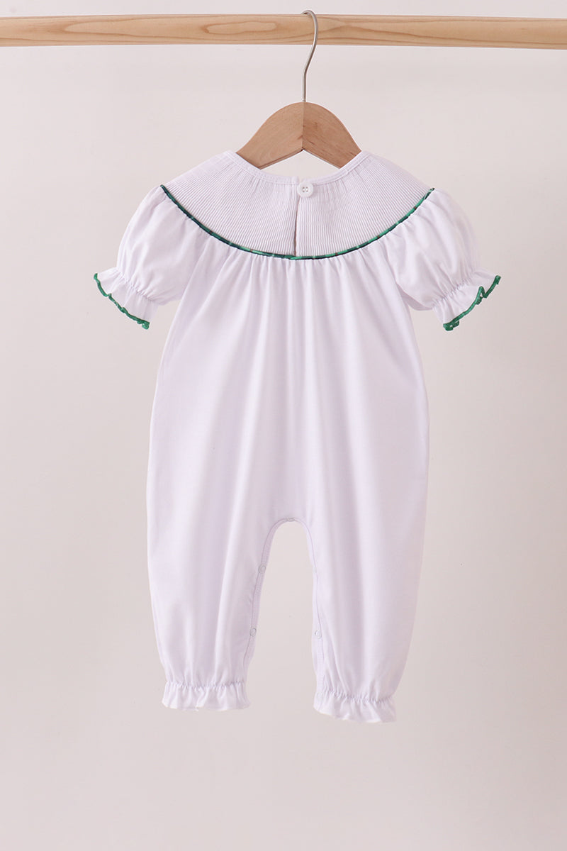 White baby romper with embroidered details on a wooden hanger against a beige background