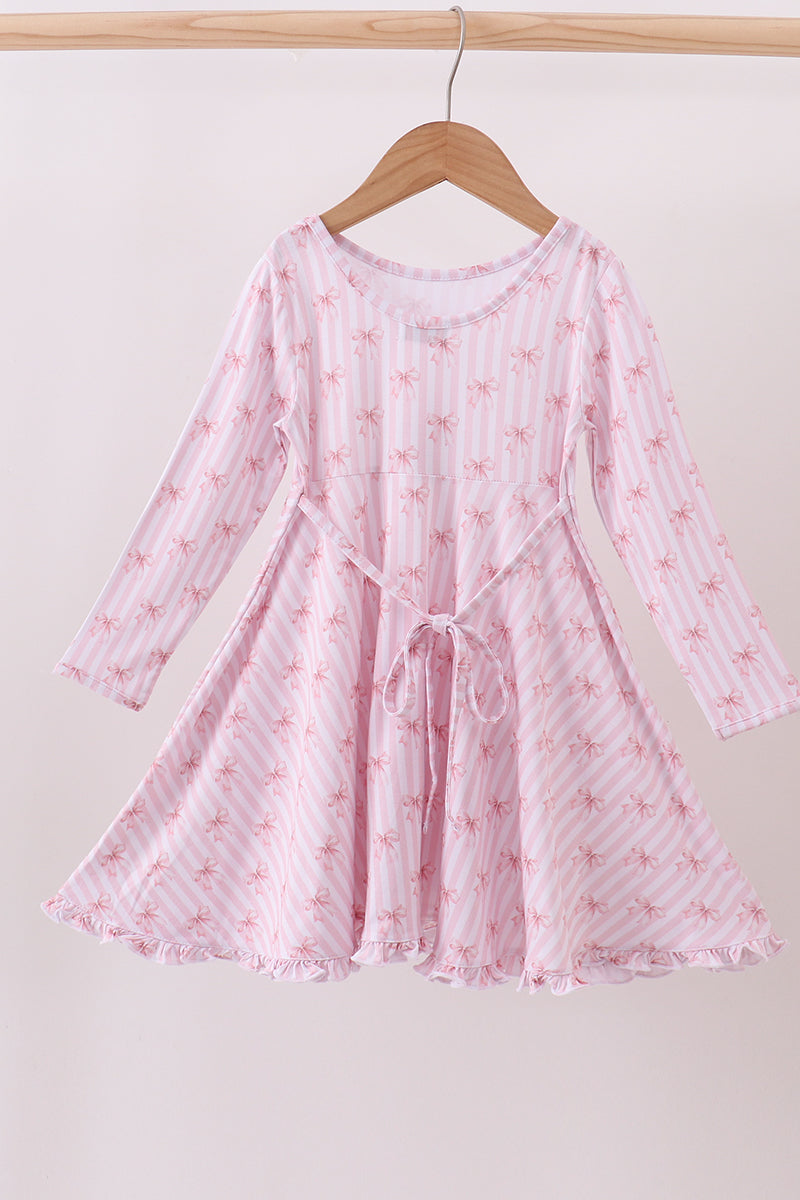Young girl wearing a pink floral nightgown against a white background